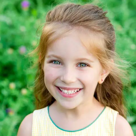 Young girl smiling outdoors