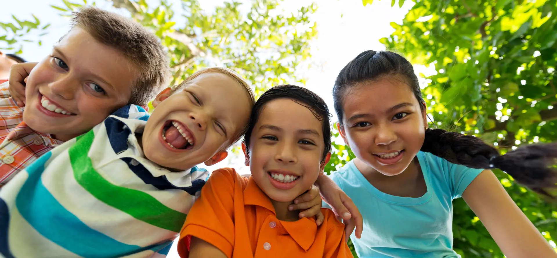Four children smiling outdoors