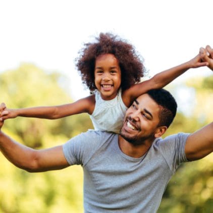 Father holding daughter on his shoulders